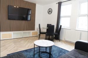 sala de estar con mesa y TV de pantalla plana en 30C Rectory Road, en Oxford