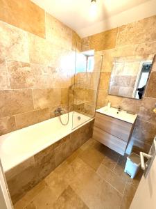 Le Petit Phuket - Appartement confortable et calme - Proche de toutes commodité - Stationnement facile à proximité في Saint-Laurent-sur-Saône: حمام مع حوض استحمام ومغسلة +صورتان