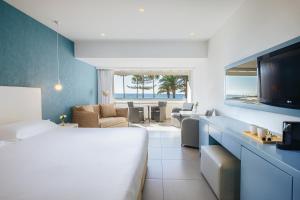 a hotel room with a bed and a television at Nissi Beach Resort in Ayia Napa