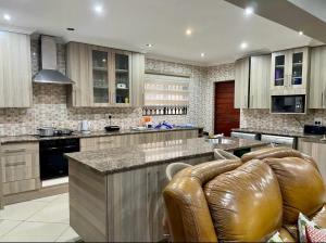 a large kitchen with a couch in the middle at Good and Proper Guest Lodge in Vereeniging