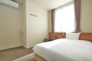Postel nebo postele na pokoji v ubytování Hotel Tohkai