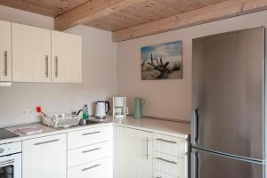 a kitchen with white cabinets and a stainless steel refrigerator at Netzschuppen in Fehmarn
