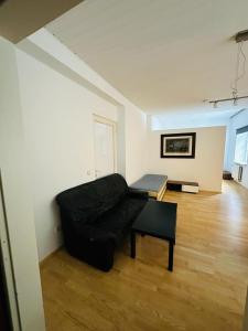 a living room with a black couch and a table at Nikola Tesla Haus, Zentrum in Graz