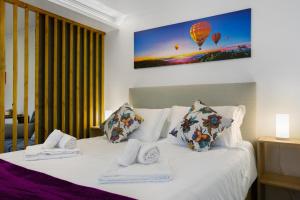 une chambre avec un lit à deux oreillers et une montgolfière dans l'établissement Litlle Zen House, à Santana