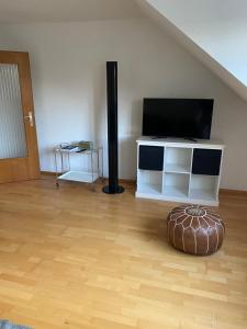 a living room with a television and a wooden floor at Schöne DG - Wohnung in Bonn in Bonn