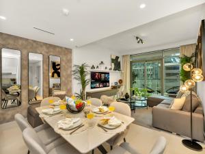 une salle à manger et un salon avec une table et des chaises dans l'établissement Designer Large 1 BR with Private Beach Infinity pool in Dubai Harbour, à Dubaï