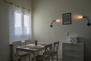 a white dining room table with chairs and a window at VILLA ATHINA in Paleokastritsa