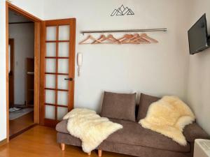 a living room with a couch and a tv at ラ・コリナ　リトリート La Colina Retreat in Madarao Kogen
