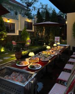 a long table with plates of food on a grill at Hôtel De Da Phu in Da Lat +97 photos