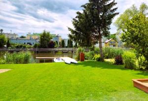 zielony dziedziniec z łodzią w trawie w obiekcie 4jeziora - prywatny dostęp do rzeki, pomost, ogrodem, wiata grillowa, rowerek wodny, kajaki i SUP w cenie, parking, psiaki dozwolone w Iławie +37 zdjęć