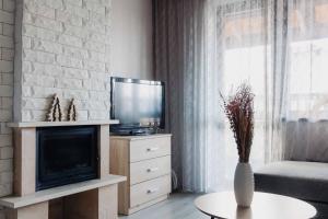 un soggiorno con TV e un vaso sul tavolo di Pirin Peaks Residence - next to Ski Lift a Bansko