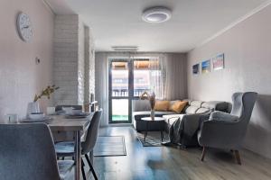 un soggiorno con un divano e un tavolo di Pirin Peaks Residence - next to Ski Lift a Bansko