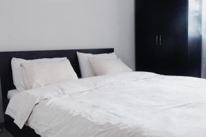 un grande letto bianco con lenzuola e cuscini bianchi di Pirin Peaks Residence - next to Ski Lift a Bansko Altre 15 foto