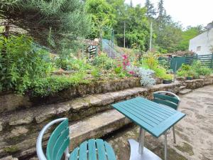 a blue table and chairs in a garden at Le Pont Haut vue sur Rivière proche Puy du Fou in Mortagne-sur-Sèvre