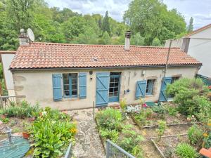a small house with blue windows and a garden at Le Pont Haut vue sur Rivière proche Puy du Fou in Mortagne-sur-Sèvre