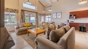 a living room with couches and a table at Misty Mountain in Sabie