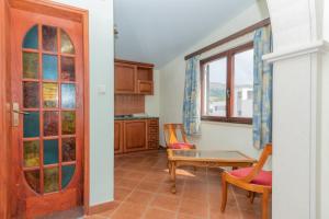 a living room with a table and chairs and a door at Apartments Magic Time in Podstrana +10 photos