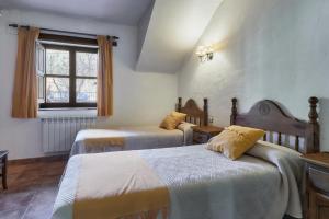 a hotel room with two beds and a window at Aldaron in Boca de Huérgano