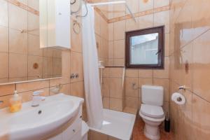 a bathroom with a sink and a toilet and a mirror at Apartments Magic Time in Podstrana