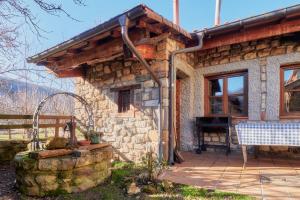 a stone house with a grill in front of it at Aldaron in Boca de Huérgano