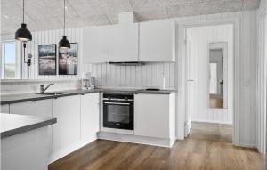 une cuisine blanche avec des armoires blanches et un évier dans l'établissement Nice Home In Harboøre With Sauna, à Harboør