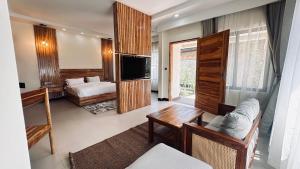 Habitación con sala de estar con sofá y TV. en Ritzy Arcadia Cottages, en Arusha 54 fotos más