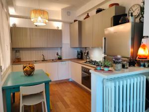 a kitchen with white cabinets and a blue table at Casa di Eva in Faenza