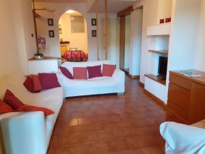 a living room with white couches and red pillows at Cordelia 9 Apartment in Luino