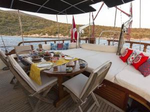 une table à manger et des chaises sur un bateau dans l'établissement Saraçoğlu vip bodrum, à Bodrum City