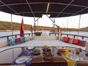 une table sur un bateau avec des assiettes de nourriture dans l'établissement Saraçoğlu vip bodrum, à Bodrum City
