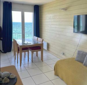 salon ze stołem i widokiem na ocean w obiekcie Paradis no Grenze Magnique vue mer w mieście Douarnenez