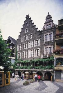 un gran edificio con gente parada frente a él en Beim Weinbauer, en Cochem