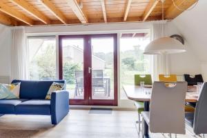 ZwiggelteにあるZomertortel I Vrijstaande Vakantiewoningの青いソファとテーブルのあるリビングルーム