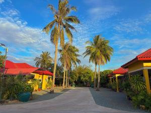 a street with palm trees in front of buildings at Coconut Village Guesthouse and Bungalow in Kep