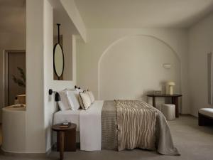 a white bedroom with a bed and a mirror at Ark in Pirgos