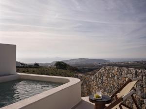 a bath tub sitting on top of a stone wall at Ark in Pirgos