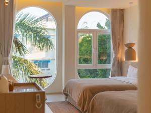 a bedroom with two beds and two windows at 礼橖LoveTime·美学海景民宿（较场尾大鹏所城店） in Shenzhen +127 photos