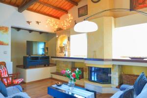un soggiorno con divano e camino di Villa Kristefi private pool Kato korakiana a Kato Korakiana