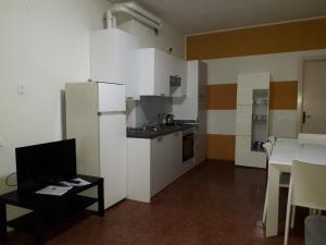 a kitchen with a white refrigerator and a table at Appartamento 2 -NEW in Cossirano