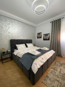 een slaapkamer met een groot bed met handdoeken erop bij Dior Apartment in Fier