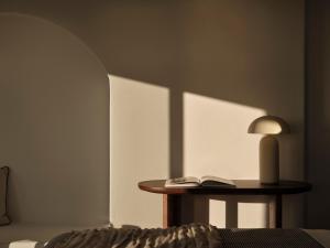 a table with a lamp and a book on it at Ark in Pirgos