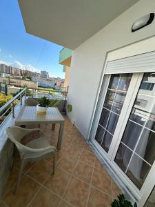 een balkon met een tafel en stoel in een gebouw bij Dior Apartment in Fier +12 foto's