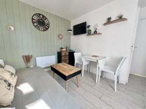 Una sala de estar con una mesa y un comedor. en Cabane au Bord du Lac - Les Jardins de Vandré - Parc Jeux Tennis Spa Nature - IDEAL FAMILLE, en Vandré