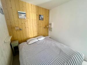 1 dormitorio con 1 cama de rayas en una habitación en Cabane au Bord du Lac - Les Jardins de Vandré - Parc Jeux Tennis Spa Nature - IDEAL FAMILLE, en Vandré