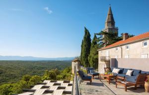 a patio with chairs and a building with a tower at Beautiful Villa Palazzo Adriana Krk in Dobrinj