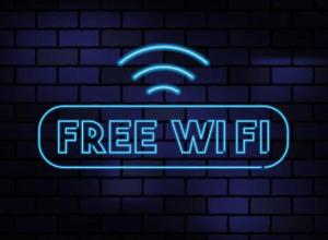 a neon sign with a free wifi sign on a brick wall at Airport Inn Manchester in Wilmslow