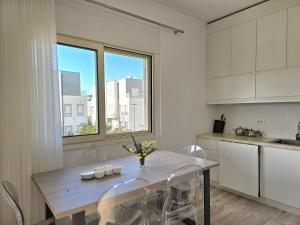 Lalzit BaySunny Beach Apartments - 253的厨房配有木桌、椅子和窗户