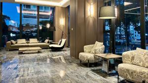 a living room with couches and chairs in a building at Landison Hotel Penang in George Town