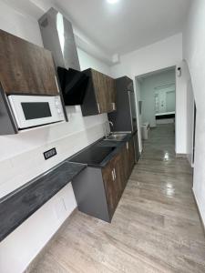 a kitchen with a sink and a microwave at Apartamento Martina 2 in Mérida