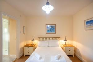 ein Schlafzimmer mit einem großen Bett und zwei Nachttischen in der Unterkunft Chymoresk - Self Catering Holiday Cottage Hayle St Ives Bay in Hayle